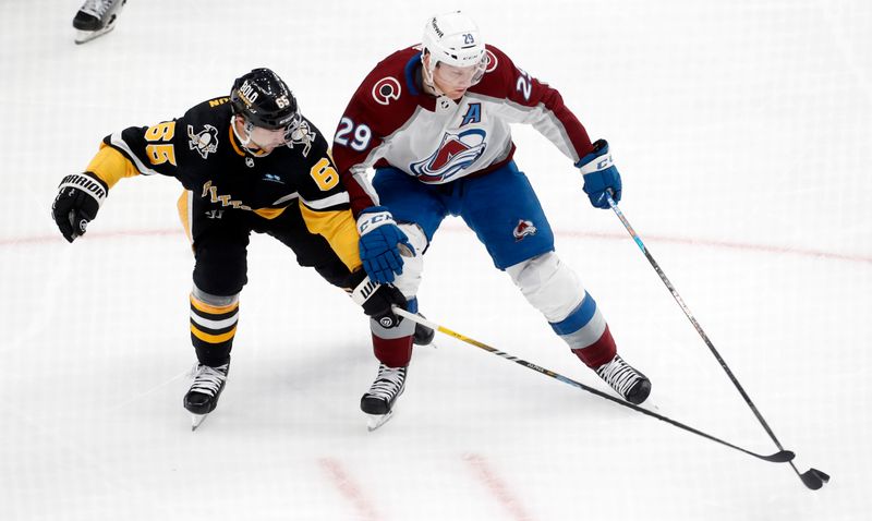 Oct 26, 2023; Pittsburgh, Pennsylvania, USA; Pittsburgh Penguins defenseman Erik Karlsson (65) defends Colorado Avalanche center Nathan MacKinnon (29) during the second period at PPG Paints Arena. Mandatory Credit: Charles LeClaire-USA TODAY Sports