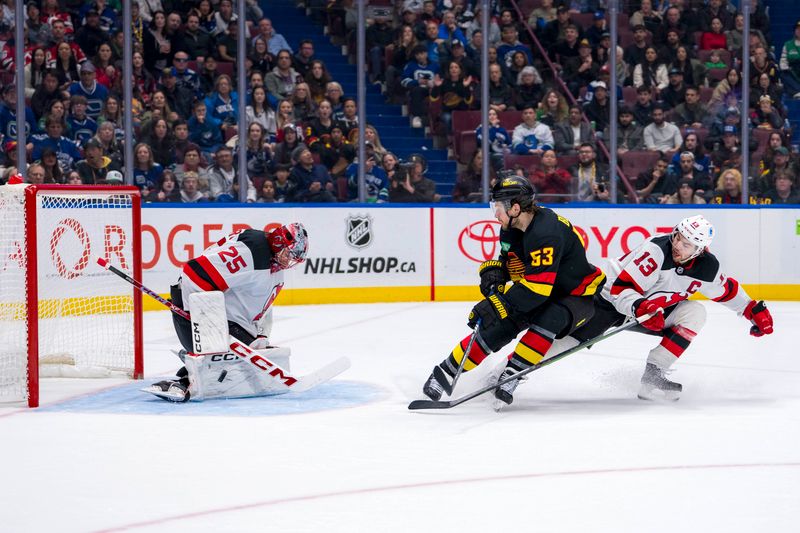 Oct 30, 2024; Vancouver, British Columbia, CAN; New Jersey Devils forward Nico Hischier (13) watches as goalie Jacob Markstrom (25) makes a save on Vancouver Canucks forward Teddy Blueger (53) during the second period at Rogers Arena. Mandatory Credit: Bob Frid-Imagn Images