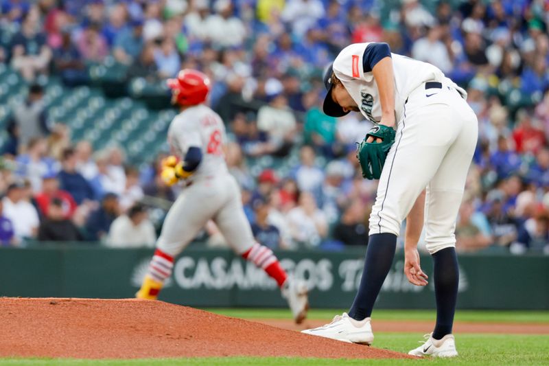 Sep 10, 2025; Seattle, Washington, USA; Seattle Mariners starting pitcher Logan Gilbert (36) reaches for the rosin bag after surrendering a solo home run to St. Louis Cardinals designated hitter Iván Herrera (48, background) during the first inning at T-Mobile Park. Mandatory Credit: Joe Nicholson-Imagn Images
