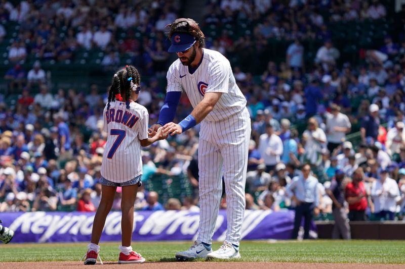 Jul 6, 2024; Chicago, Illinois, USA; Chicago Cubs shortstop Dansby Swanson (7) signs an autograph before the game against the Los Angeles Angels at Wrigley Field. Mandatory Credit: David Banks-USA TODAY Sports