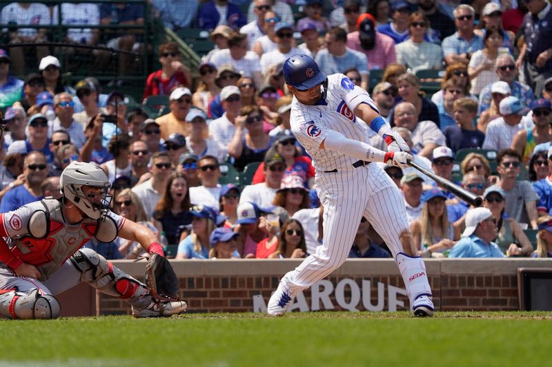 Aug 6, 2025; Chicago, Illinois, USA; Chicago Cubs designated hitter Seiya Suzuki (27) hits a one run sacrifice against the Cincinnati Reds during the third inning at Wrigley Field. Mandatory Credit: David Banks-Imagn Images
