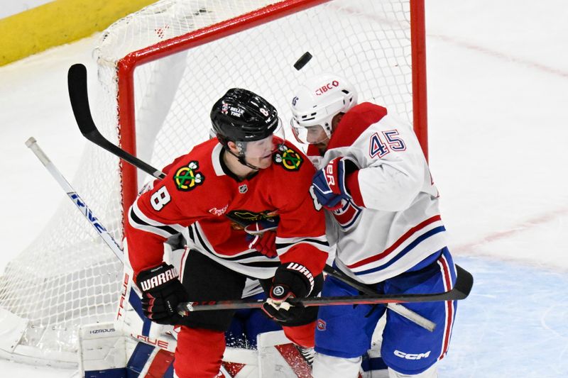 Jan 3, 2025; Chicago, Illinois, USA;  Chicago Blackhawks center Ryan Donato (8) and Montreal Canadiens defenseman Alexandre Carrier (45) dodge the puck during the third period at United Center. Mandatory Credit: Matt Marton-Imagn Images