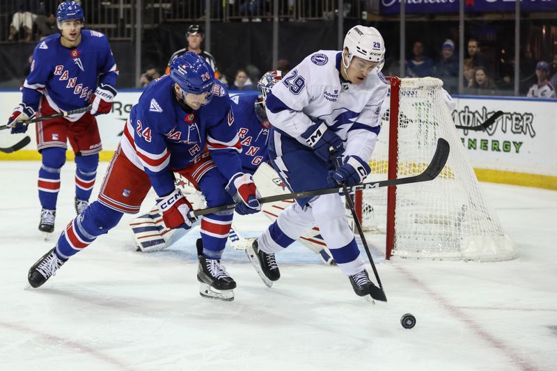 Nov 29, 2025; New York, New York, USA;  New York Rangers defenseman Carson Soucy (24) and Tampa Bay Lightning right wing Pontus Holmberg (29) battle for control of the puck at Madison Square Garden. Mandatory Credit: Wendell Cruz-Imagn Images