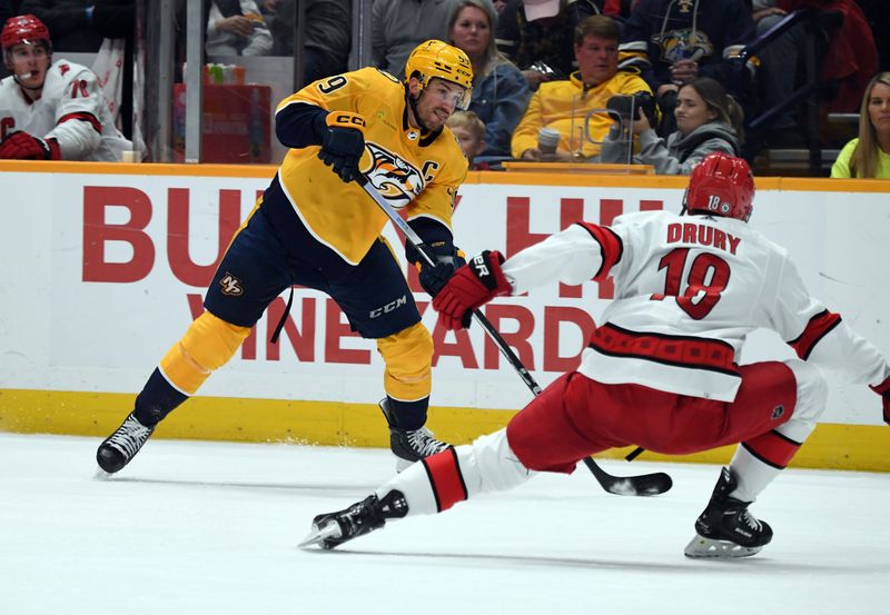 Dec 27, 2023; Nashville, Tennessee, USA; Nashville Predators defenseman Roman Josi (59) shoots the puck as he is defended by Carolina Hurricanes center Jack Drury (18) during the third period  at Bridgestone Arena. Mandatory Credit: Christopher Hanewinckel-USA TODAY Sports