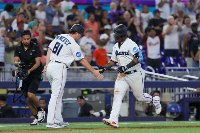 Jul 30, 2023; Miami, Florida, USA; Miami Marlins third baseman Jean Segura (9) celebrates with third base coach Griffin Benedict (81) after hitting a home run against the Detroit Tigers during the eighth inning at loanDepot Park. Mandatory Credit: Sam Navarro-USA TODAY Sports