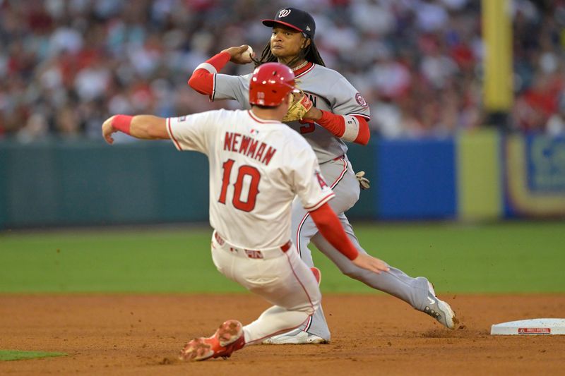 Jun 28, 2025; Anaheim, California, USA;  Los Angeles Angels third baseman Kevin Newman (10) is out as Washington Nationals shortstop CJ Abrams (5) throws to first to complete a double play in the sixth inning at Angel Stadium. Mandatory Credit: Jayne Kamin-Oncea-Imagn Images