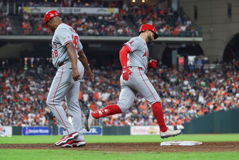 Sep 20, 2024; Houston, Texas, USA; Los Angeles Angels center fielder Kevin Pillar (12) rounds first base past first base coach Bo Porter (88) after hitting a home run during the seventh inning against the Houston Astros at Minute Maid Park. Mandatory Credit: Troy Taormina-Imagn Images