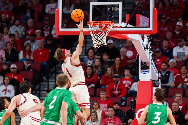 Dec 21, 2025; Lincoln, Nebraska, USA; Nebraska Cornhuskers guard Sam Hoiberg (1) shoots the ball against North Dakota Fighting Hawks guard Greyson Uelmen (3) during the second half at Pinnacle Bank Arena. Mandatory Credit: Dylan Widger-Imagn Images