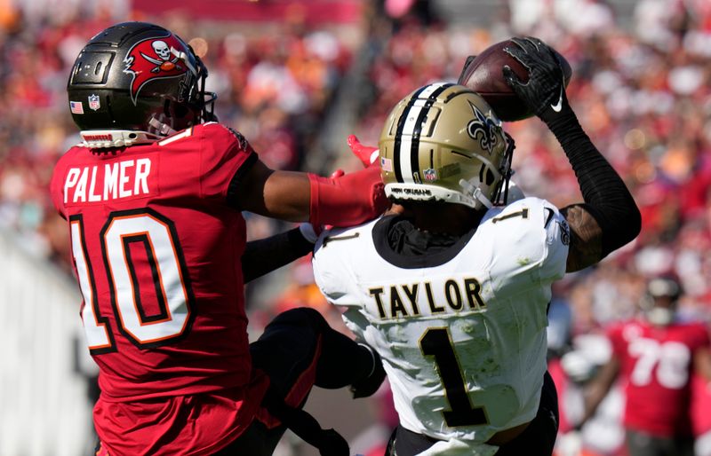 New Orleans Saints cornerback Alontae Taylor (1) intercepts a pass intended for Tampa Bay Buccaneers wide receiver Trey Palmer (10) during the first half of an NFL football game Sunday, Dec. 31, 2023, in Tampa, Fla. (AP Photo/Chris O'Meara)