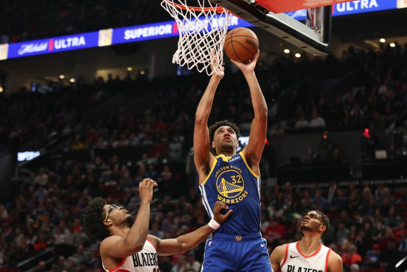 PORTLAND, OREGON - APRIL 11: Trayce Jackson-Davis #32 of the Golden State Warriors drives to the basket against Scoot Henderson #00 (L) and Rayan Rupert #72 of the Portland Trail Blazers during the second quarter at Moda Center on April 11, 2024 in Portland, Oregon. NOTE TO USER: User expressly acknowledges and agrees that, by downloading and or using this photograph, User is consenting to the terms and conditions of the Getty Images License Agreement.? (Photo by Amanda Loman/Getty Images)