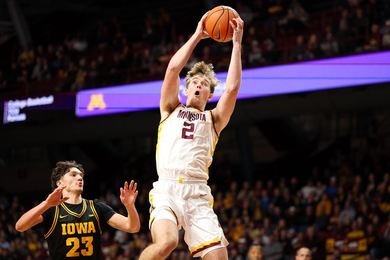 Jan 6, 2026; Minneapolis, Minnesota, USA; Minnesota Golden Gophers forward Grayson Grove (2) jumps for a pass as Iowa Hawkeyes guard Isaia Howard (23) defends during the first half at Williams Arena. Mandatory Credit: Matt Krohn-Imagn Images