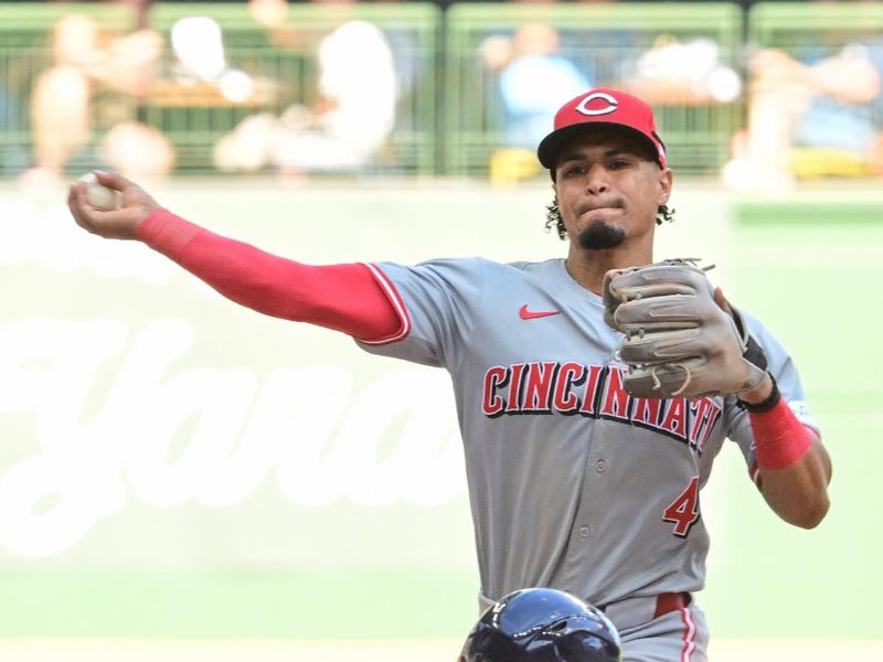 Aug 11, 2024; Milwaukee, Wisconsin, USA;  Cincinnati Reds second baseman Santiago Espinal (4) completes a double play after forcing out Milwaukee Brewers second baseman Brice Turang (2) in the eighth inning at American Family Field. Mandatory Credit: Benny Sieu-USA TODAY Sports