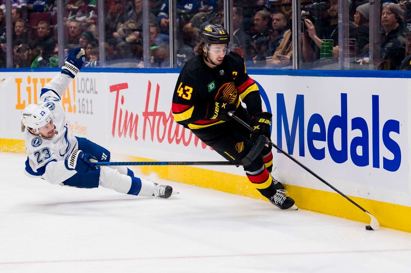 Dec 12, 2023; Vancouver, British Columbia, CAN; Tampa Bay Lightning forward Michael Eyssimont (23) looses an edge pursuing Vancouver Canucks defenseman Quinn Hughes (43) in the first period at Rogers Arena. Mandatory Credit: Bob Frid-USA TODAY Sports