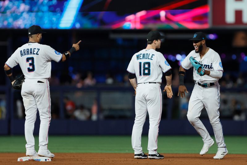 Jun 25, 2023; Miami, Florida, USA; Miami Marlins left fielder Bryan De La Cruz (14) celebrates with shortstop Joey Wendle (18) and second baseman Luis Arraez (3) after winning the game against the Pittsburgh Pirates at loanDepot Park. Mandatory Credit: Sam Navarro-USA TODAY Sports