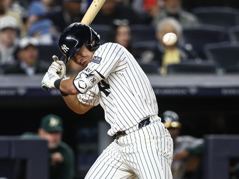 Apr 24, 2024; Bronx, New York, USA; New York Yankees shortstop Anthony Volpe (11) leans back to avoid getting hit by a pitch in the fourth inning against the Oakland Athletics at Yankee Stadium. Mandatory Credit: Wendell Cruz-USA TODAY Sports