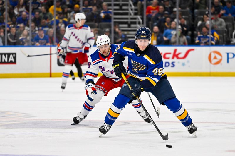 Jan 11, 2024; St. Louis, Missouri, USA;  St. Louis Blues defenseman Scott Perunovich (48) controls the puck against the New York Rangers during the third period at Enterprise Center. Mandatory Credit: Jeff Curry-USA TODAY Sports