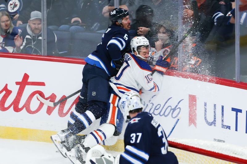 Nov 30, 2023; Winnipeg, Manitoba, CAN; Winnipeg Jets defenseman Brenden Dillon (5) boards Edmonton Oilers forward Derek Ryan (10) during the third period at Canada Life Centre. Mandatory Credit: Terrence Lee-USA TODAY Sports