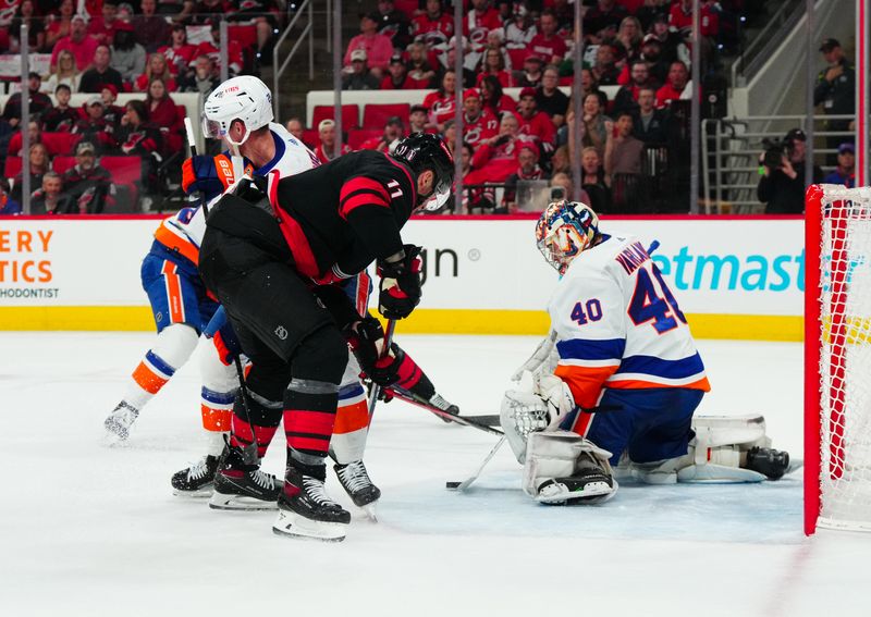 Apr 20, 2024; Raleigh, North Carolina, USA; Carolina Hurricanes center Sebastian Aho (20) can’t get to the puck against New York Islanders center Brock Nelson (29) and  goaltender Semyon Varlamov (40) during the first period n game one of the first round of the 2024 Stanley Cup Playoffs at PNC Arena. Mandatory Credit: James Guillory-USA TODAY Sports