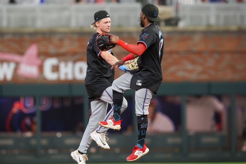 Aug 3, 2024; Atlanta, Georgia, USA; Miami Marlins left fielder Kyle Stowers (28) and second baseman Vidal Brujan (17) celebrate after a victory over the Atlanta Braves at Truist Park. Mandatory Credit: Brett Davis-USA TODAY Sports