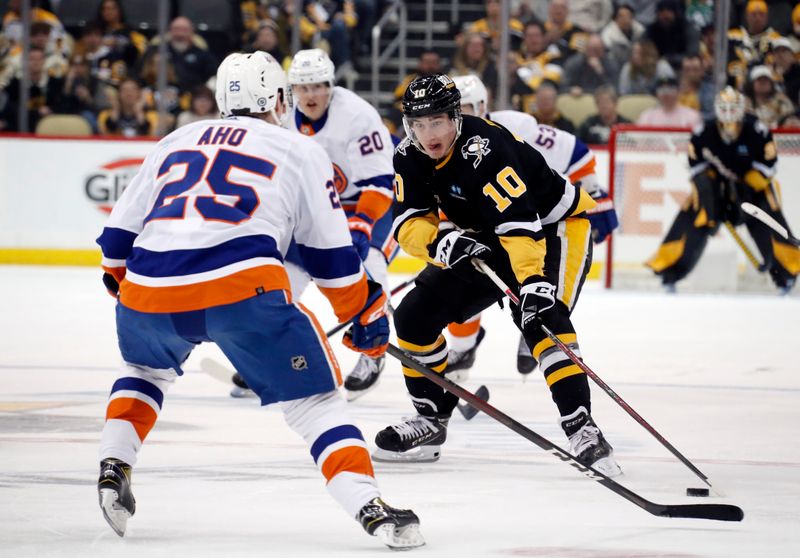 Mar 9, 2023; Pittsburgh, Pennsylvania, USA;  Pittsburgh Penguins left wing Drew O'Connor (10) skates up ice with the puck against the New York Islanders during the third period at PPG Paints Arena. The Islanders won 4-3 in overtime. Mandatory Credit: Charles LeClaire-USA TODAY Sports