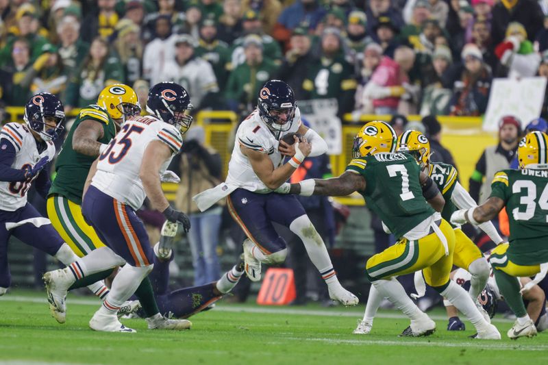 Chicago Bears quarterback Justin Fields (1) tries to run past the defense of Green Bay Packers linebacker Quay Walker (7) during an NFL football game between the Green Bay Packers and Chicago Bears Sunday, Jan. 7, 2024, in Green Bay, Wis. (AP Photo/Matt Ludtke)