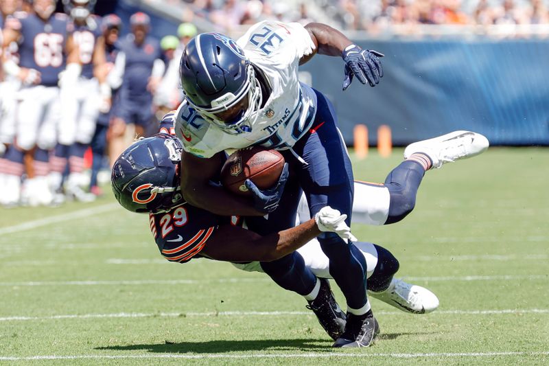 Tennessee Titans running back Tyjae Spears (32) is tackled by Chicago Bears cornerback Tyrique Stevenson (29) during the first half of an NFL preseason football game, Saturday, Aug. 12, 2023, in Chicago. (AP Photo/Kamil Krzaczynski)