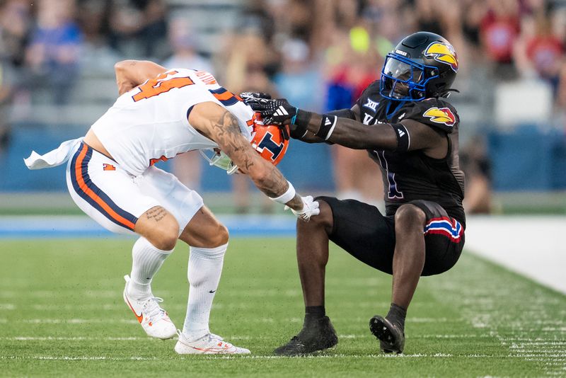 Sep 8, 2023; Lawrence, Kansas, USA; Illinois Fighting Illini wide receiver Casey Washington (14) is tackled by Kansas Jayhawks safety Kenny Logan Jr. (1) during the first half at David Booth Kansas Memorial Stadium. Mandatory Credit: Jay Biggerstaff-USA TODAY Sports