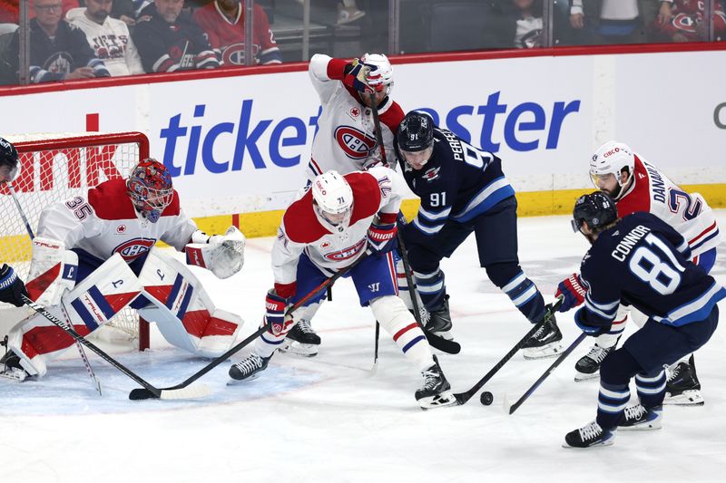 Feb 4, 2026; Winnipeg, Manitoba, CAN; Winnipeg Jets left wing Kyle Connor (81) and Montreal Canadiens center Phillip Danault (24) dig for the puck in front of goaltender Samuel Montembeault (35) during the third period at Canada Life Centre. Mandatory Credit: James Carey Lauder-Imagn Images