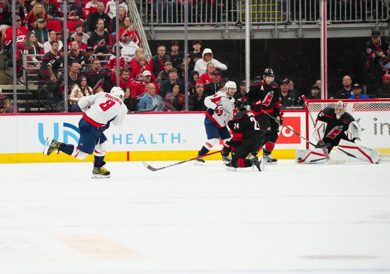 Nov 3, 2024; Raleigh, North Carolina, USA;  Carolina Hurricanes goaltender Pyotr Kochetkov (52) stops the shot attempt by Washington Capitals left wing Alex Ovechkin (8) during the third period at Lenovo Center. Mandatory Credit: James Guillory-Imagn Images