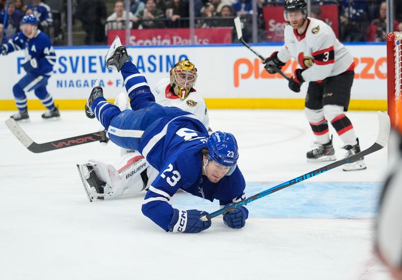 Dec 27, 2025; Toronto, Ontario, CAN; Toronto Maple Leafs forward Matthew Knies (23) falls to the ice after scoring on Ottawa Senators goaltender Leevi Merilainen (1) during the third period at Scotiabank Arena. Mandatory Credit: John E. Sokolowski-Imagn Images