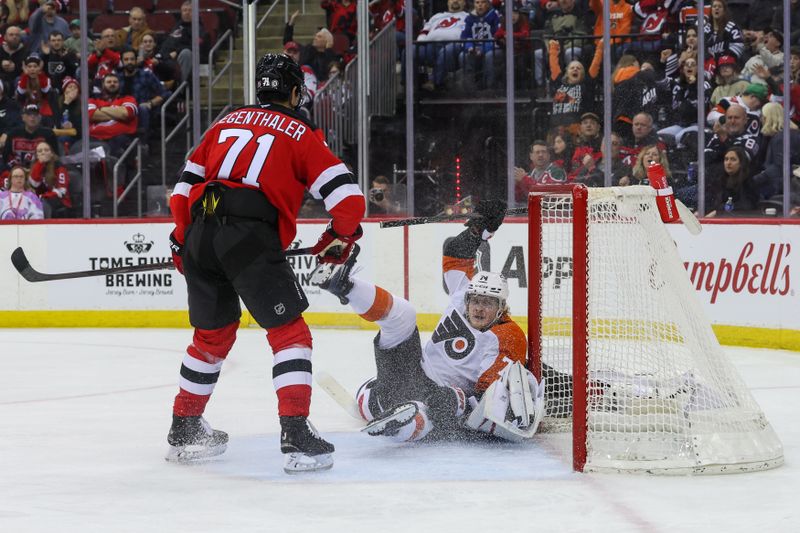 Jan 18, 2025; Newark, New Jersey, USA; Philadelphia Flyers right wing Owen Tippett (74) crashes into New Jersey Devils goaltender Jake Allen (34) during the third period at Prudential Center. Mandatory Credit: Ed Mulholland-Imagn Images