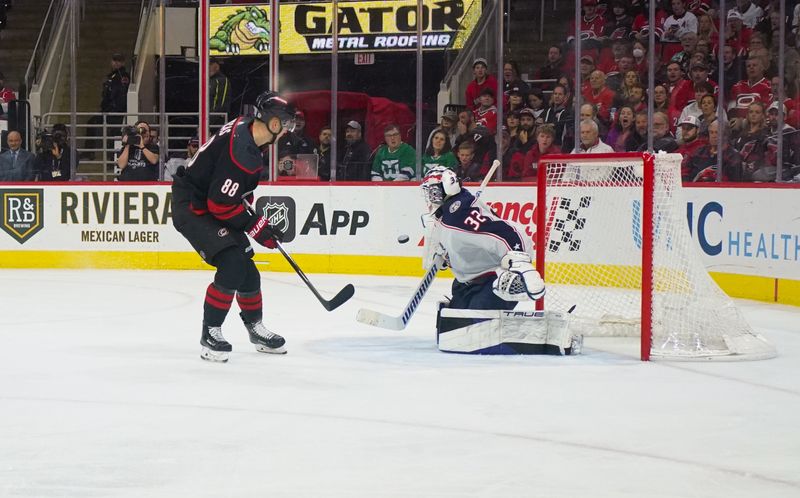 Apr 7, 2024; Raleigh, North Carolina, USA;  Columbus Blue Jackets goalie Malcolm Subban (32) stops the scoring chance by Carolina Hurricanes center Martin Necas (88) during the third period at PNC Arena. Mandatory Credit: James Guillory-USA TODAY Sports