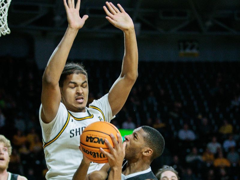 Mar 2, 2024; Wichita, Kansas, USA; Wichita State Shockers forward Kenny Pohto (11) blocks Rice Owls guard Travis Evee (3) during the second half at Charles Koch Arena. Mandatory Credit: William Purnell-USA TODAY Sports