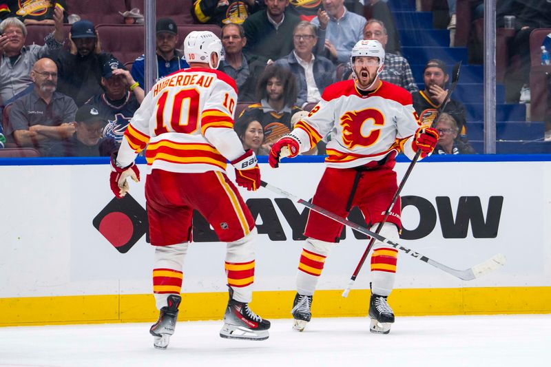 Oct 9, 2024; Vancouver, British Columbia, CAN; Calgary Flames forward Jonathan Huberdeau (10) and defenseman MacKenzie Weegar (52) celebrate Weager’s goal against the Vancouver Canucks during the third period at Rogers Arena. Mandatory Credit: Bob Frid-Imagn Images