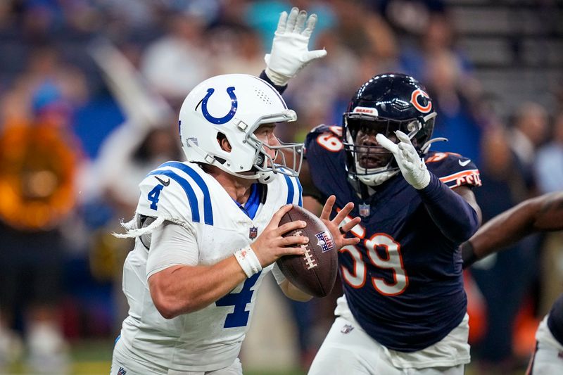 Indianapolis Colts quarterback Sam Ehlinger (4) runs from Chicago Bears linebacker Jalen Harris (59) during the second half of an NFL preseason football game in Indianapolis, Saturday, Aug. 19, 2023. (AP Photo/Darron Cummings)