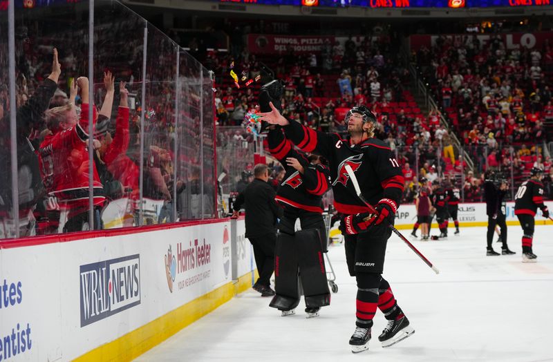 Oct 31, 2024; Raleigh, North Carolina, USA;  Carolina Hurricanes center Jordan Staal (11) tosses candy to the fans after the game against the Boston Bruins at Lenovo Center. Mandatory Credit: James Guillory-Imagn Images