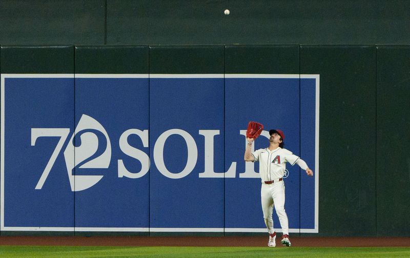 Jun 28, 2024; Phoenix, Arizona, USA; Arizona Diamondbacks outfielder Corbin Carroll (7) tracks a deep fly ball to center field in the fourth inning against the Oakland Athletics at Chase Field. Mandatory Credit: Allan Henry-USA TODAY Sports