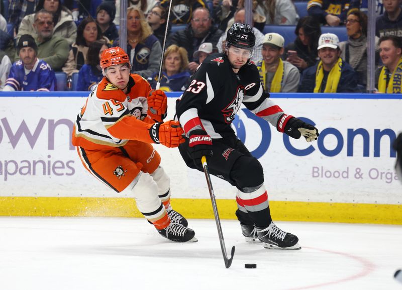 Jan 10, 2026; Buffalo, New York, USA;  Buffalo Sabres defenseman Mattias Samuelsson (23) controls the puck as Anaheim Ducks right wing Beckett Sennecke (45) defends during the first period at KeyBank Center. Mandatory Credit: Timothy T. Ludwig-Imagn Images