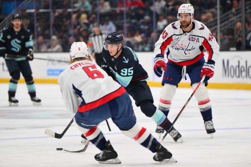 Jan 23, 2025; Seattle, Washington, USA; Seattle Kraken left wing Andre Burakovsky (95) plays the puck while defended by Washington Capitals defenseman Jakob Chychrun (6) during the first period at Climate Pledge Arena. Mandatory Credit: Steven Bisig-Imagn Images