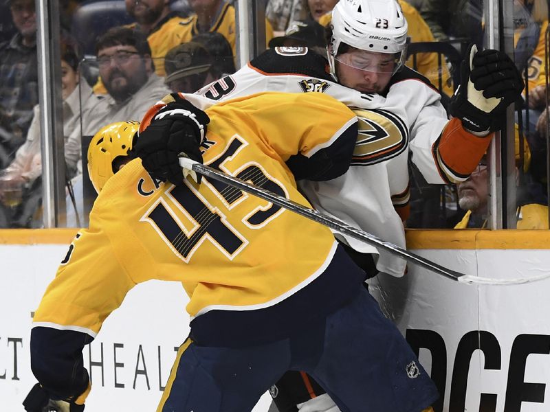 Jan 9, 2024; Nashville, Tennessee, USA; Anaheim Ducks center Mason McTavish (23) is hit by Nashville Predators defenseman Alexandre Carrier (45) during the second period at Bridgestone Arena. Mandatory Credit: Christopher Hanewinckel-USA TODAY Sports