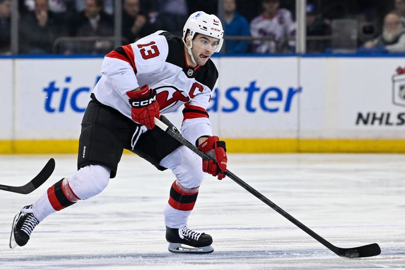 Dec 2, 2024; New York, New York, USA; New Jersey Devils center Nico Hischier (13) skates with the puck against the New York Rangers during the first period at Madison Square Garden. Mandatory Credit: Dennis Schneidler-Imagn Images