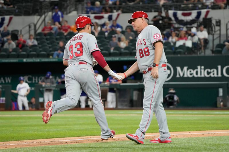 Apr 14, 2022; Arlington, Texas, USA; Los Angeles Angels catcher Max Stassi (33) celebrates his two run home run with third base coach Phil Nevin (88) against the Texas Rangers during the eighth inning of a baseball game at Globe Life Field. Mandatory Credit: Jim Cowsert-USA TODAY Sports