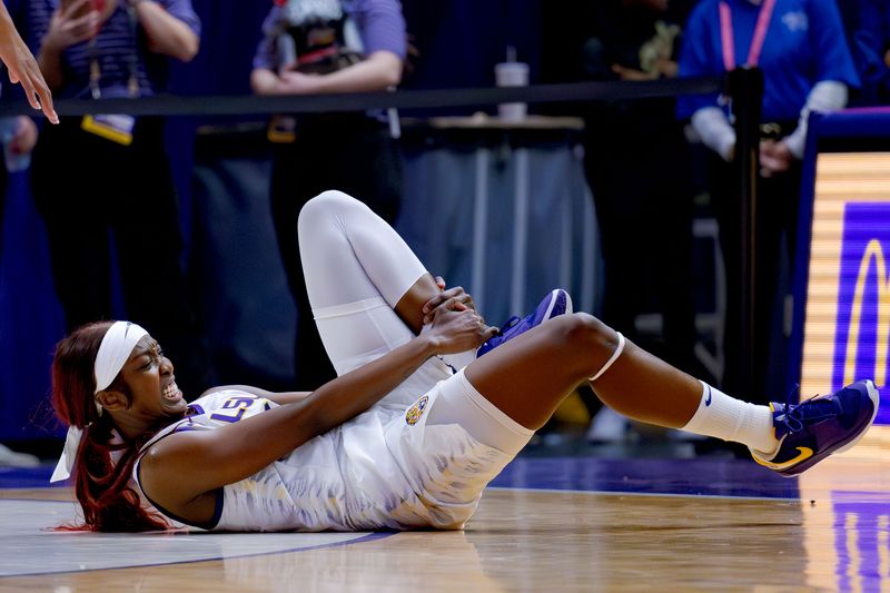 Feb 22, 2024; Baton Rouge, Louisiana, USA; LSU Lady Tigers guard Flau'jae Johnson (4) grabs her ankle during the second half against the Auburn Tigers at Pete Maravich Assembly Center. Mandatory Credit: Matthew Hinton-USA TODAY Sports