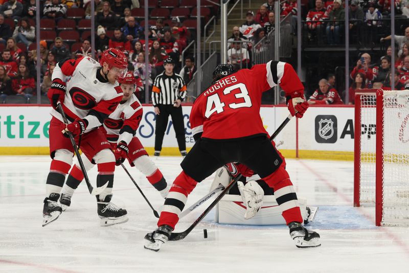 Jan 4, 2026; Newark, New Jersey, USA; New Jersey Devils defenseman Luke Hughes (43) knocks the puck into his own goal against the Carolina Hurricanes during the first period at Prudential Center. Carolina Hurricanes left wing Nikolaj Ehlers (27) was credited with the goal. Mandatory Credit: Ed Mulholland-Imagn Images