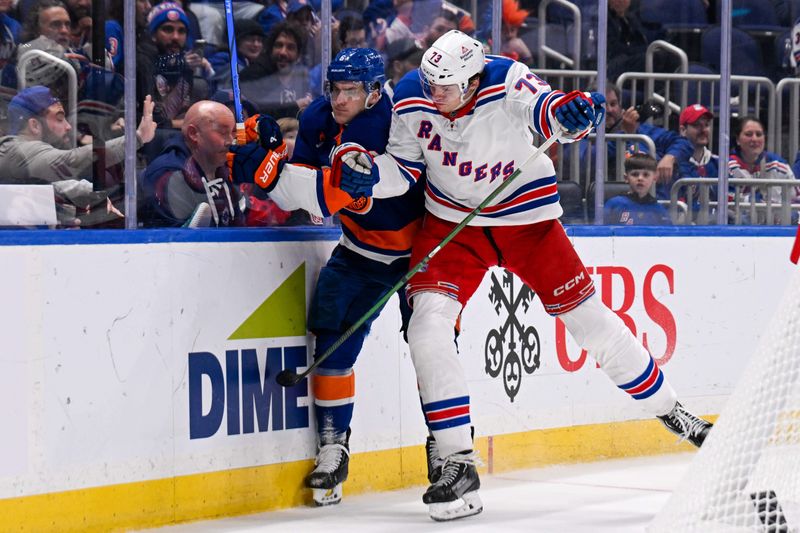 Apr 10, 2025; Elmont, New York, USA;  New York Rangers center Matt Rempe (73) checks New York Islanders defenseman Ryan Pulock (6) into the boards during the third period at UBS Arena. Mandatory Credit: Dennis Schneidler-Imagn Images