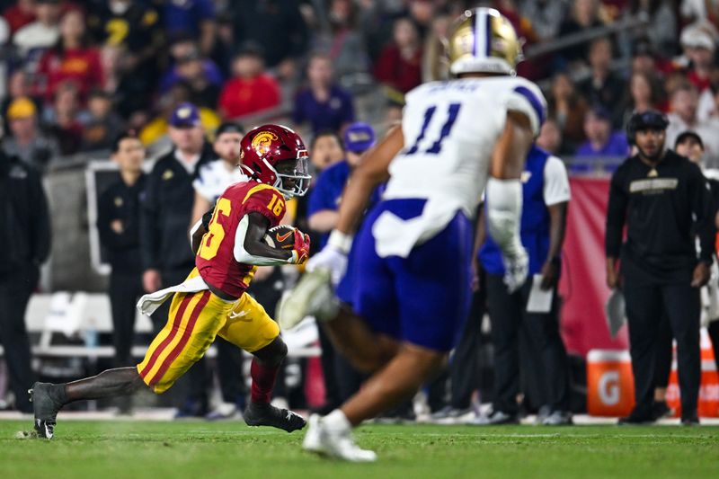 Nov 4, 2023; Los Angeles, California, USA; USC Trojans wide receiver Tahj Washington (16) carries the ball against Washington Huskies linebacker Alphonzo Tuputala (11) during the third quarter at United Airlines Field at Los Angeles Memorial Coliseum. Mandatory Credit: Jonathan Hui-USA TODAY Sports