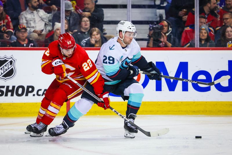 Mar 4, 2024; Calgary, Alberta, CAN; Seattle Kraken defenseman Vince Dunn (29) and Calgary Flames center Jakob Pelletier (22) battles for the puck during the second period at Scotiabank Saddledome. Mandatory Credit: Sergei Belski-USA TODAY Sports