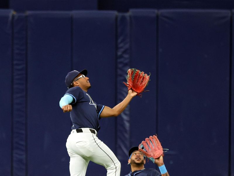 Jun 25, 2024; St. Petersburg, Florida, USA; Tampa Bay Rays outfielder Richie Palacios (1) catches the ball over outfielder Jose Siri (22) against the Seattle Mariners during the first inning  at Tropicana Field. Mandatory Credit: Kim Klement Neitzel-USA TODAY Sports