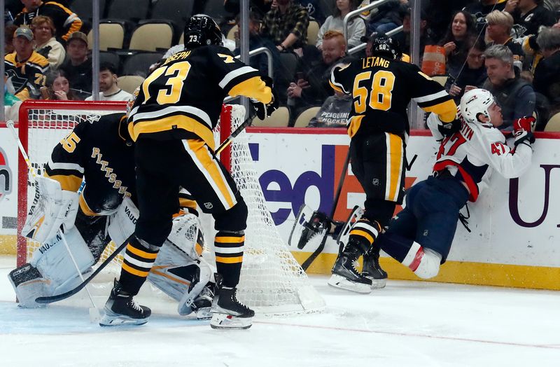 Mar 7, 2024; Pittsburgh, Pennsylvania, USA;  Pittsburgh Penguins defenseman Kris Letang (58) checks Washington Capitals left wing Beck Malenstyn (47) behind the Penguins net during the second period at PPG Paints Arena. Mandatory Credit: Charles LeClaire-USA TODAY Sports