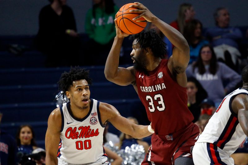 Feb 11, 2023; Oxford, Mississippi, USA; South Carolina Gamecocks forward Josh Gray (33) handles the ball as Mississippi Rebels forward Jayveous McKinnis (0) defends during the second half at The Sandy and John Black Pavilion at Ole Miss. Mandatory Credit: Petre Thomas-USA TODAY Sports